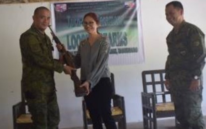 <p>DAS GUNS. Mayor Mariam Mangudadatu of Datu Abdullah Sangki in Maguindanao hands over a rifle to Lt. Colonel Lauro Oliveros, chief of 1st Mechanized Infantry Battalion in Ampatuan, Maguindanao, during a ceremony on Friday. (6th ID photo)</p>